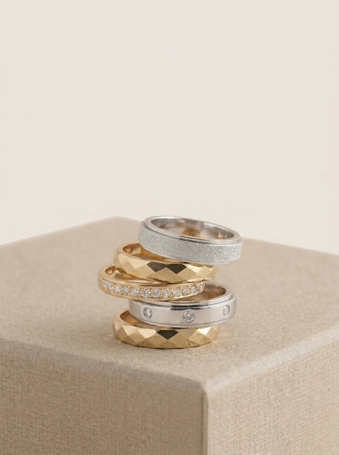 Set of gold and silver rings on a beige surface