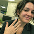 Woman in an office setting showing a ring on her finger