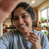 Woman smiling in a kitchen with plants in the background