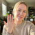 Woman showing off a ring in a cozy living room.