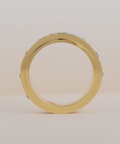 Gold ring with green gemstones on a beige background