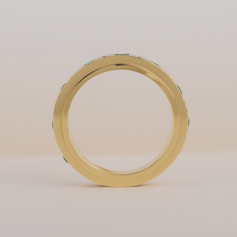 Gold ring with green gemstones on a beige background