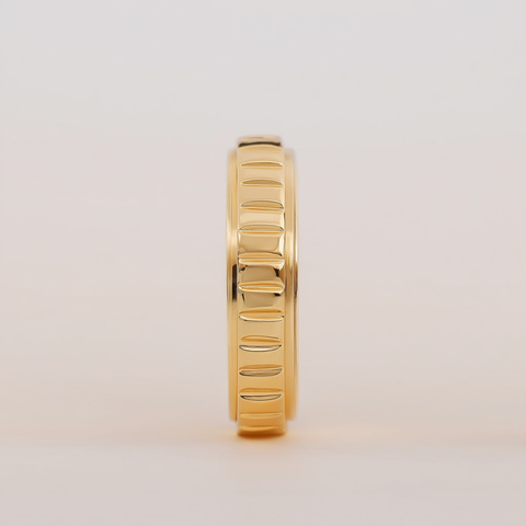 Gold ring with a textured band on a light beige background