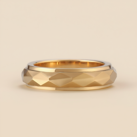 Gold ring with a textured band on a beige background