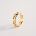 Gold ring with blue gemstones on a light gray background