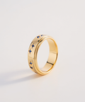 Gold ring with blue gemstones on a light gray background