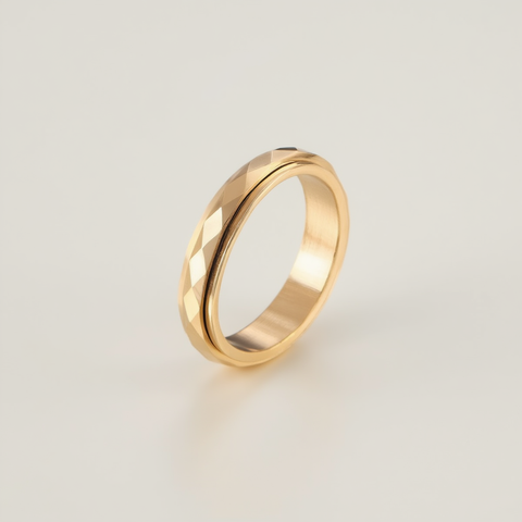 Gold ring with a textured design on a light beige background