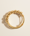 Gold beaded ring on a beige background