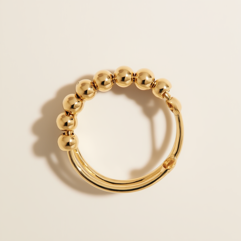 Gold beaded ring on a beige background