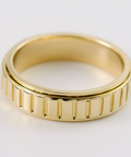 Gold ring with a textured band on a white background