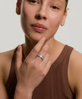 Woman wearing a brown sleeveless top with a plain background
