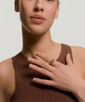 Woman wearing a brown sleeveless top with a plain background