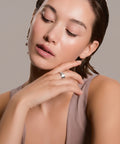 Woman with a ring on her finger against a neutral background