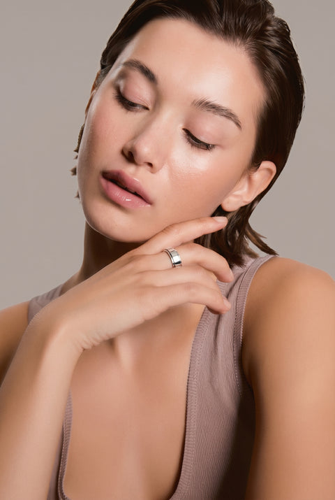 Woman with a ring on her finger against a neutral background
