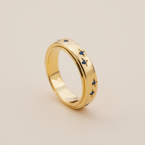 Gold ring with blue gemstones on a beige background