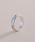 Silver ring with blue butterfly patterns on a light gray background