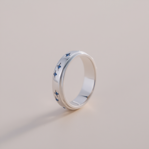 Silver ring with blue butterfly patterns on a light gray background