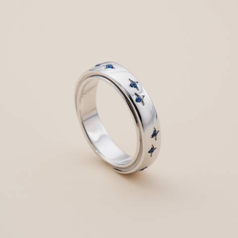 Silver ring with blue accents on a beige background