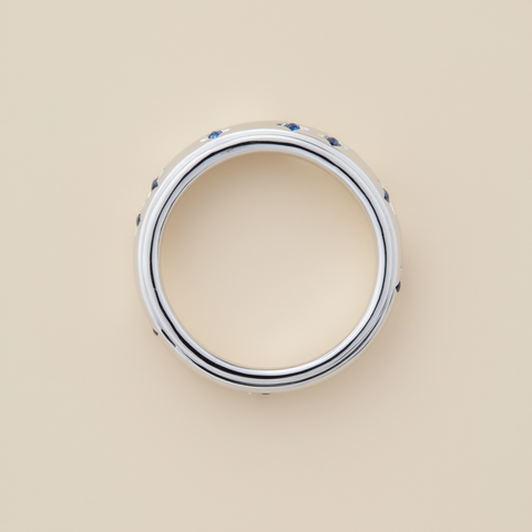 Silver ring with blue stones on a beige background