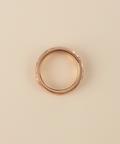 Rose gold ring on a beige background