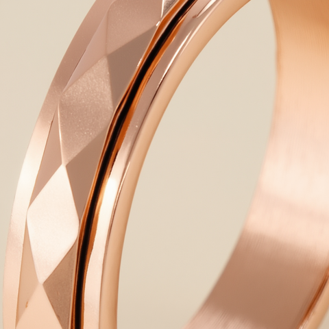 Close-up of a rose gold ring with geometric design on a beige background