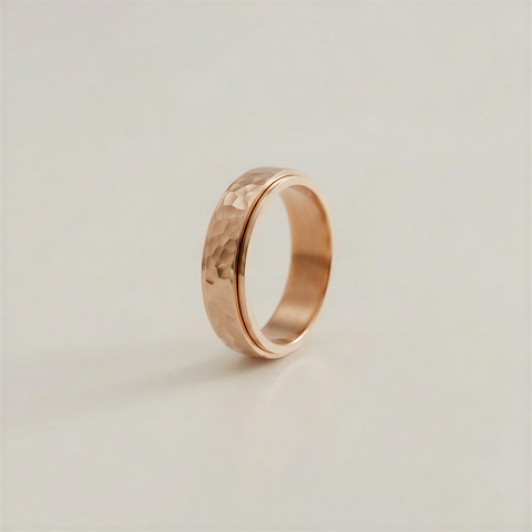 Rose gold ring with a textured surface on a light beige background
