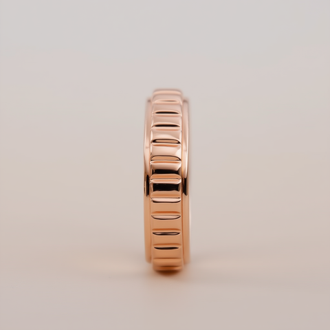 Rose gold ring with a textured design on a beige background