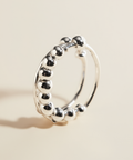 Silver hoop earring on a beige background