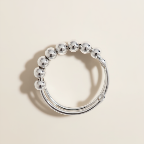 Silver beaded ring on a beige background
