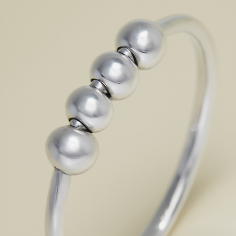 Silver bracelet with round beads on a beige background