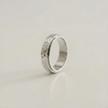 Silver ring with a textured surface on a light beige background