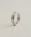 Silver ring with a textured surface on a light beige background