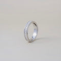 Silver ring with small stones on a light gray background
