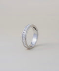 Silver ring with small stones on a light gray background
