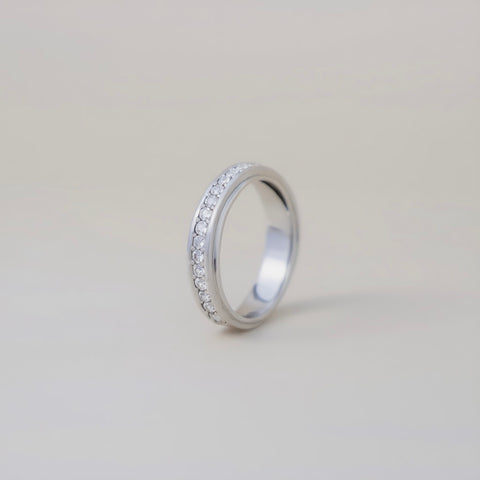 Silver ring with small stones on a light gray background