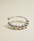 Silver beaded ring on a beige background