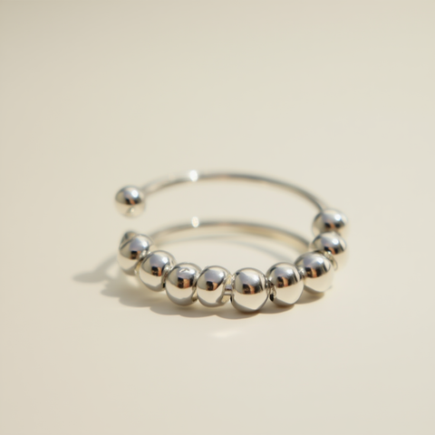 Silver beaded ring on a beige background
