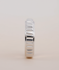 Silver ring with a textured band on a light beige background