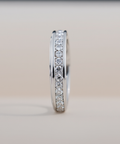 Silver ring with small diamonds on a light gray background