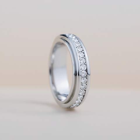 Silver ring with small diamonds on a light beige background