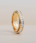Gold ring with embedded diamonds on a light background