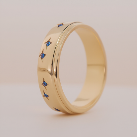 Gold ring with blue gemstones on a light background