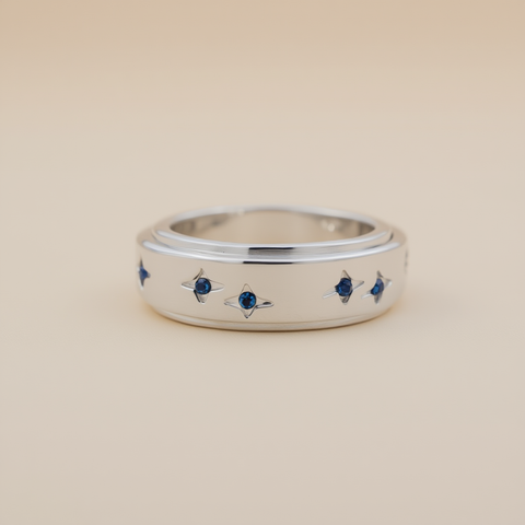 Silver ring with small blue stones on a beige background