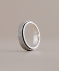 Silver ring with textured surface on a beige background