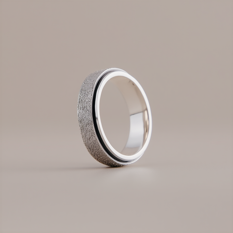 Silver ring with textured surface on a beige background