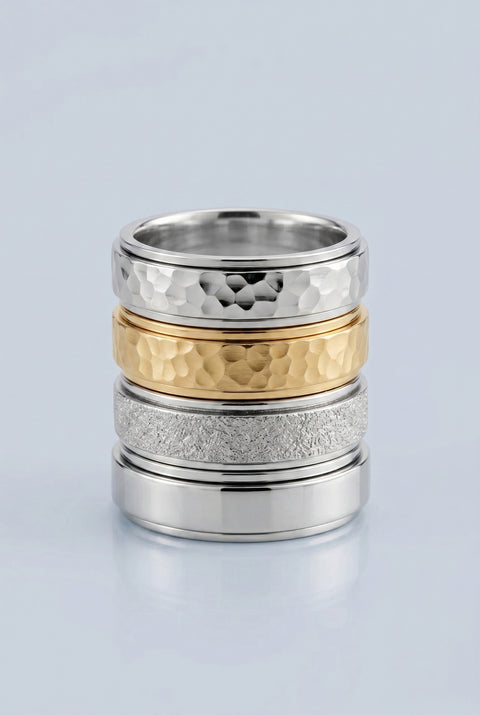 Three metallic rings with textured surfaces stacked on a light gray background