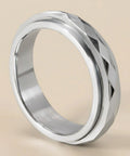 Silver ring with geometric design on a beige background