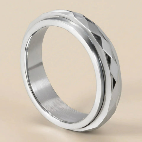 Silver ring with geometric design on a beige background