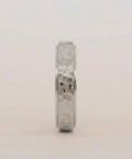 Silver ring with a textured band on a light gray background