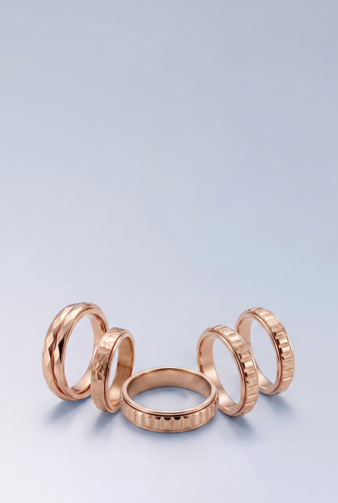 Set of rose gold rings on a light blue background